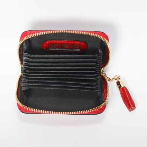 Black wallet with red interior and zipper on a white background