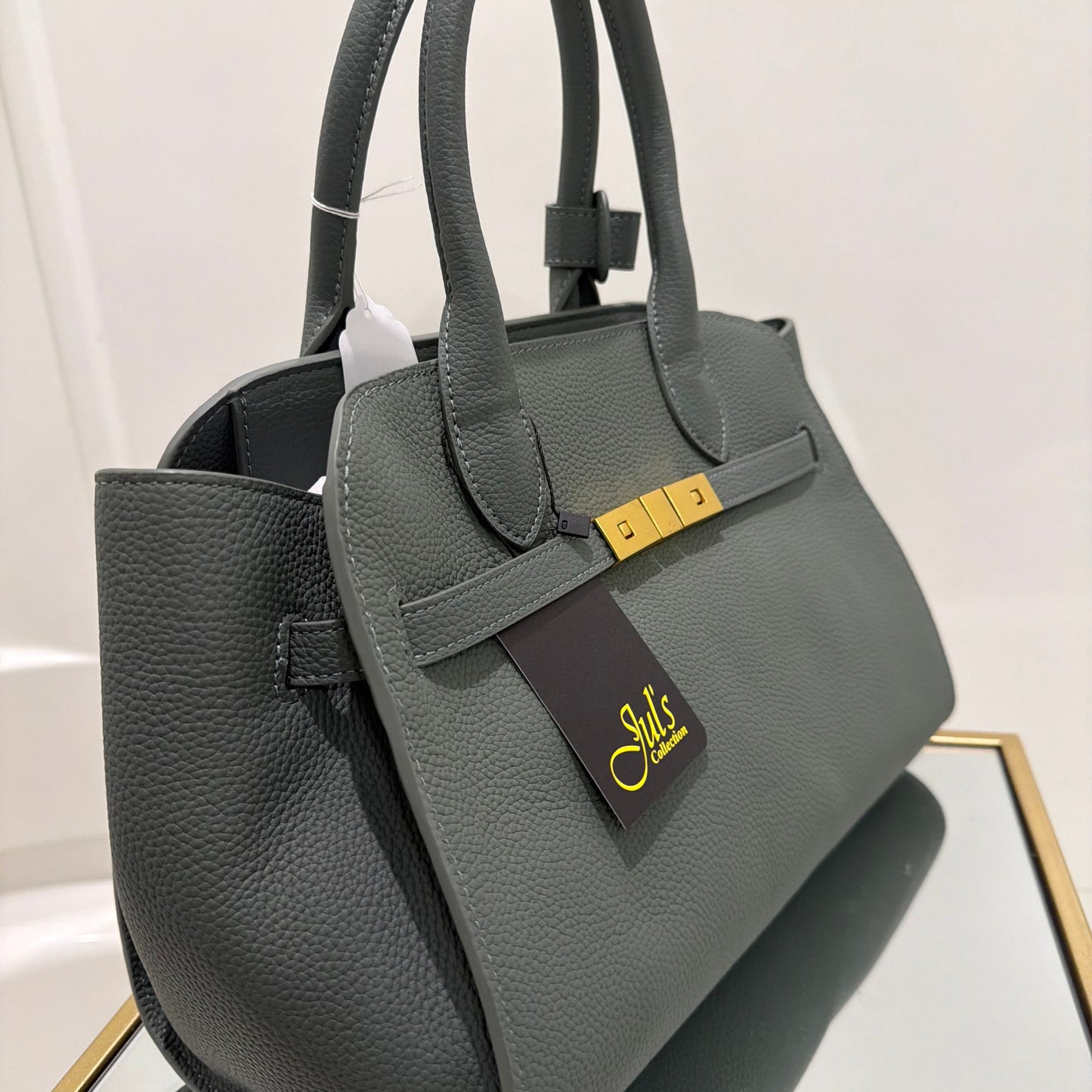 Gray handbag with a brand logo on a white background