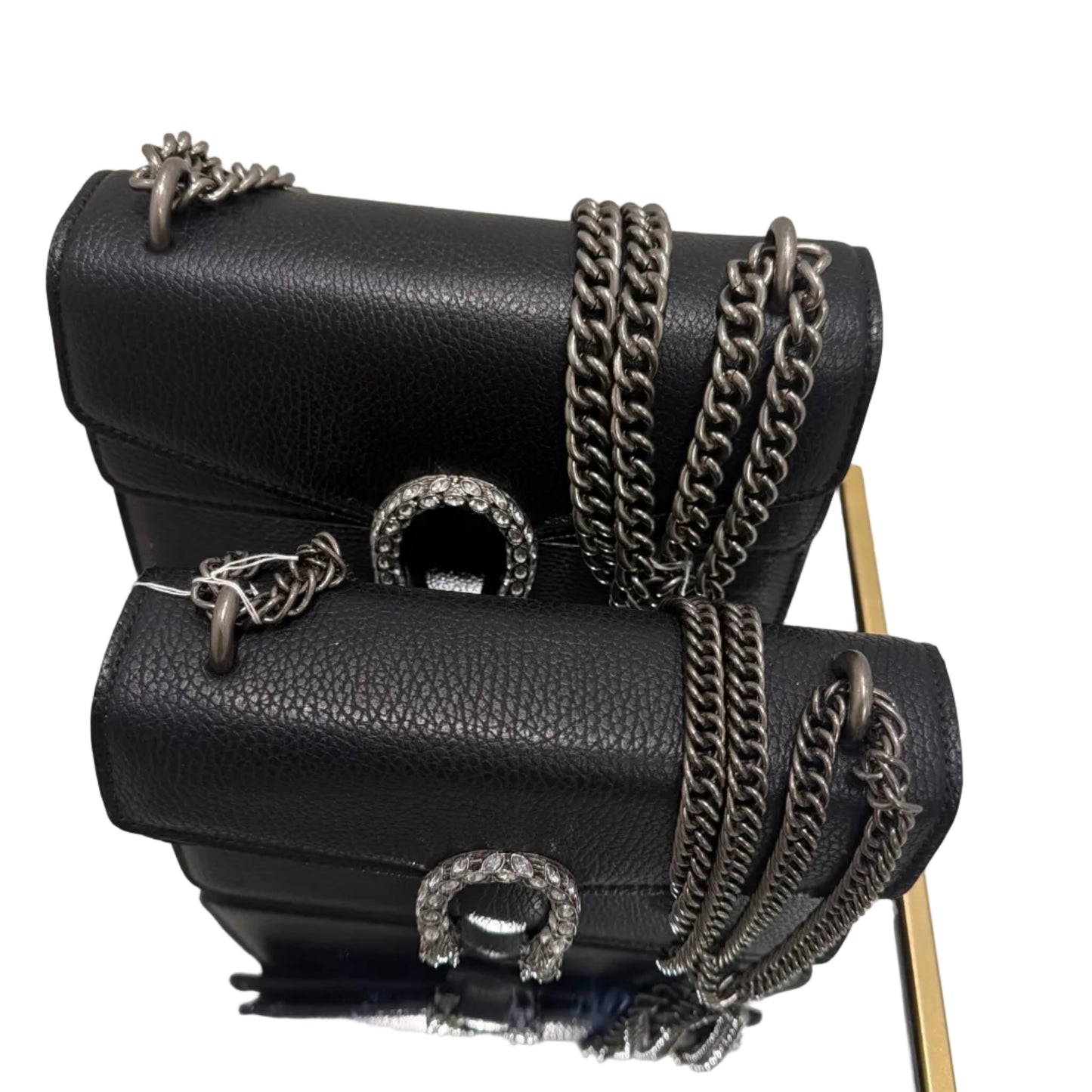 Black handbag with chain details and a visible logo, reflected in a mirror.