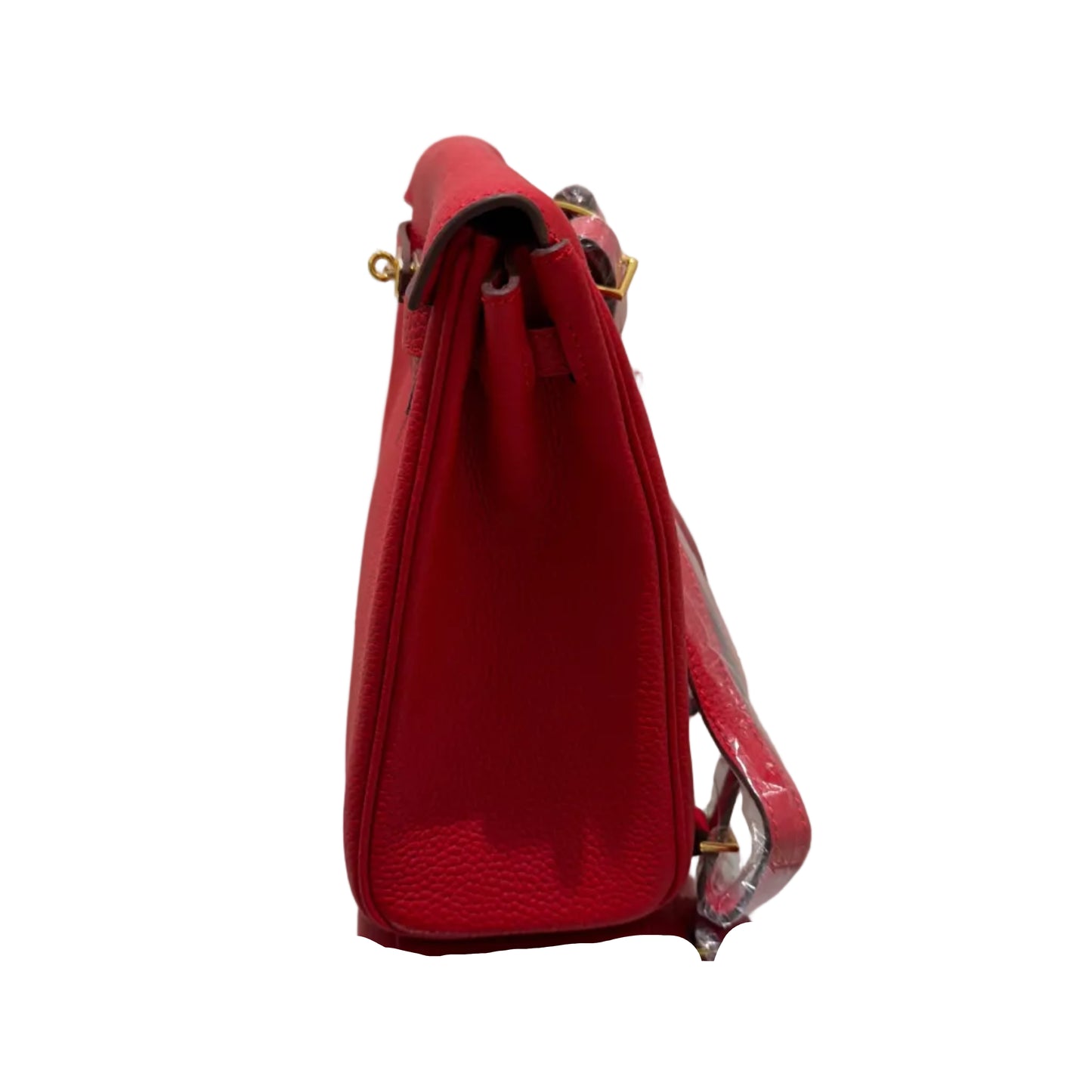 Red handbag on a white surface with a gold frame