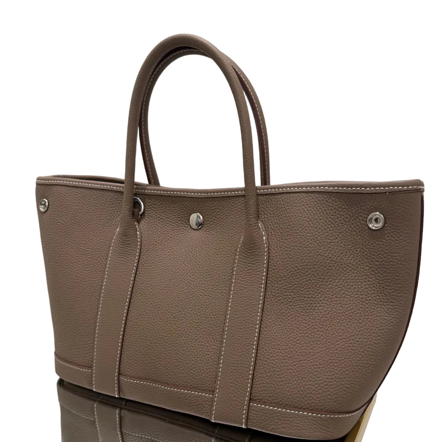 Brown leather bag with visible stitching on a white background