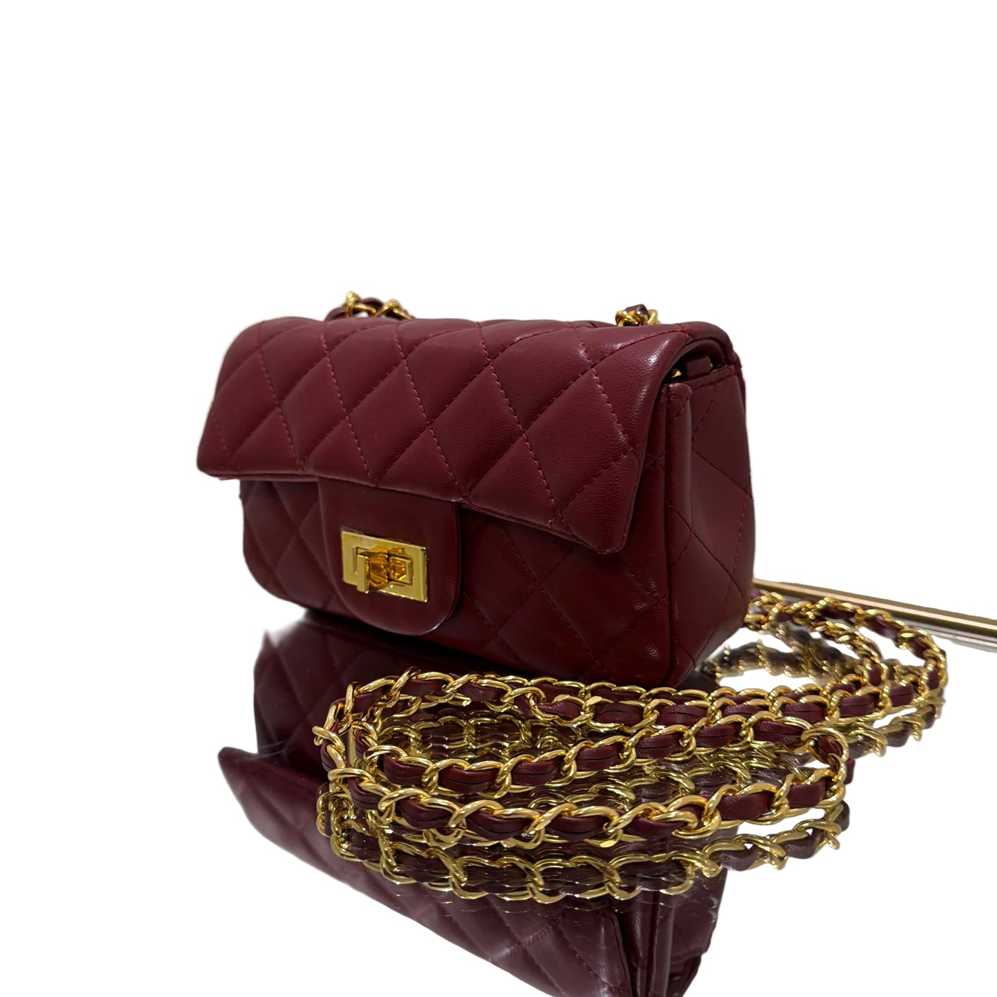 Maroon quilted handbag with gold chain strap on a white background