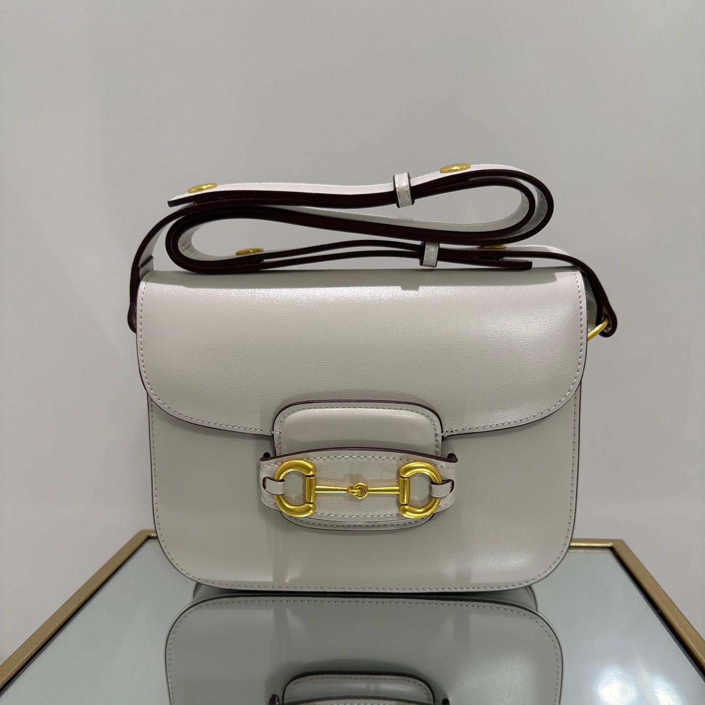 Two light gray handbags with gold hardware on a white background