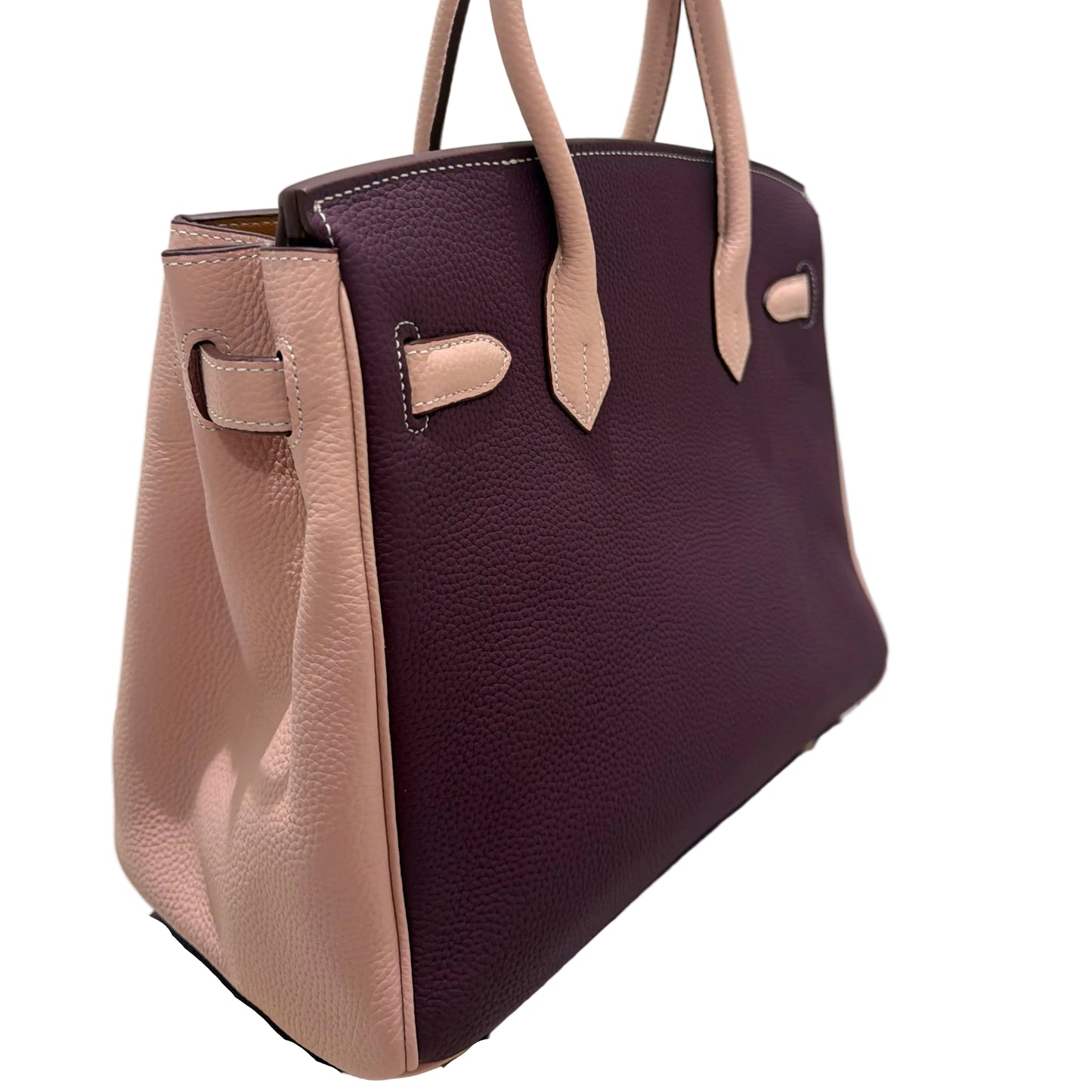 Purple handbag with beige accents on a reflective surface