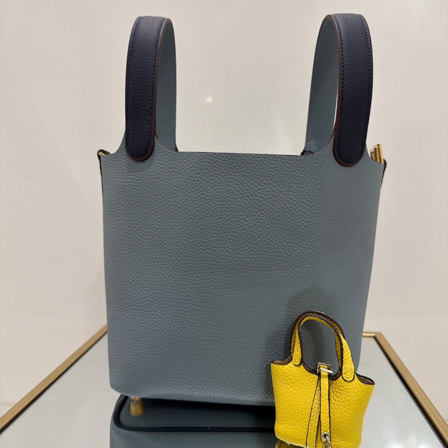 Gray handbag with black handles on a light gray background