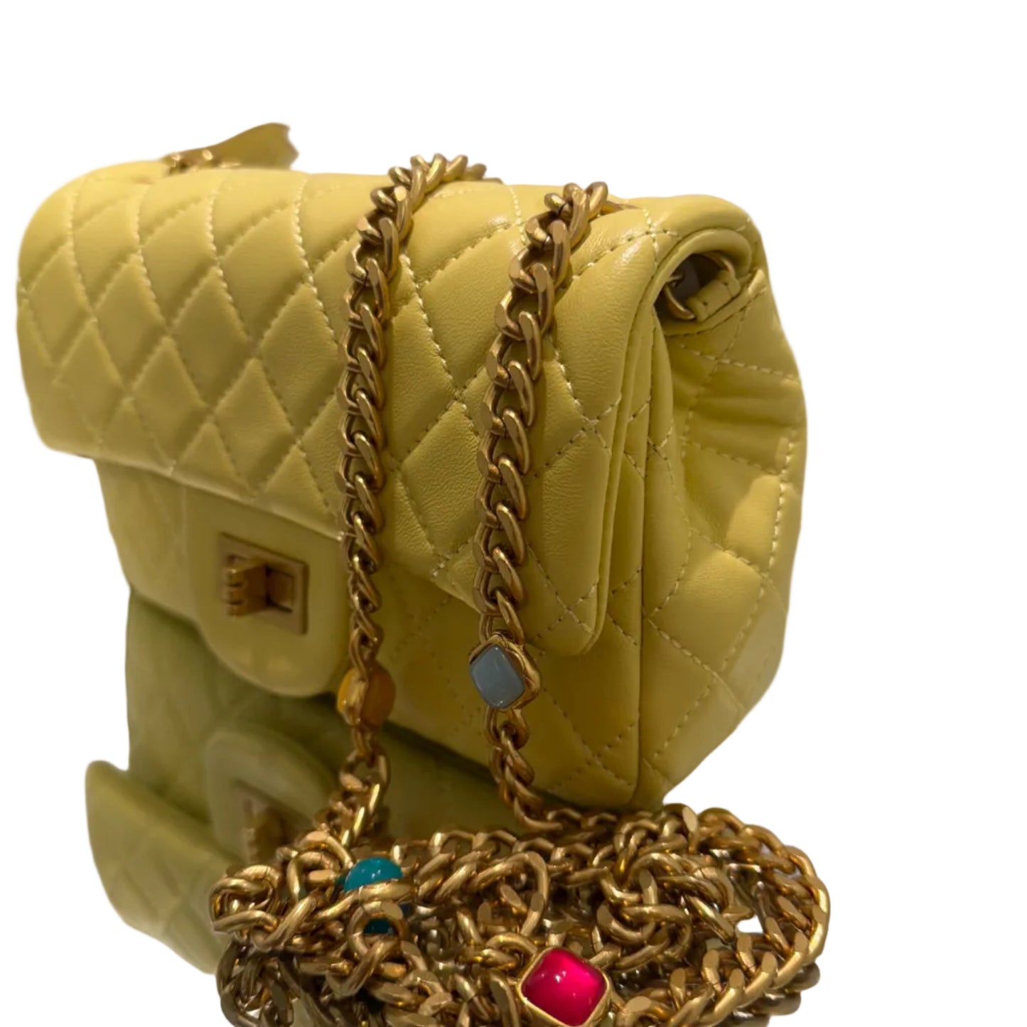Yellow quilted handbag with gold chain and decorative clasp on a white background