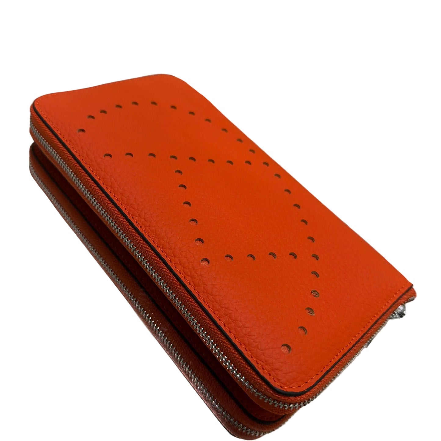 Orange leather wallet with perforated design on a glass surface
