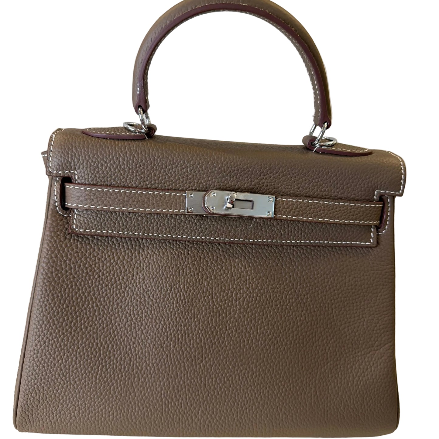 Brown leather handbag with a silver clasp on a light background