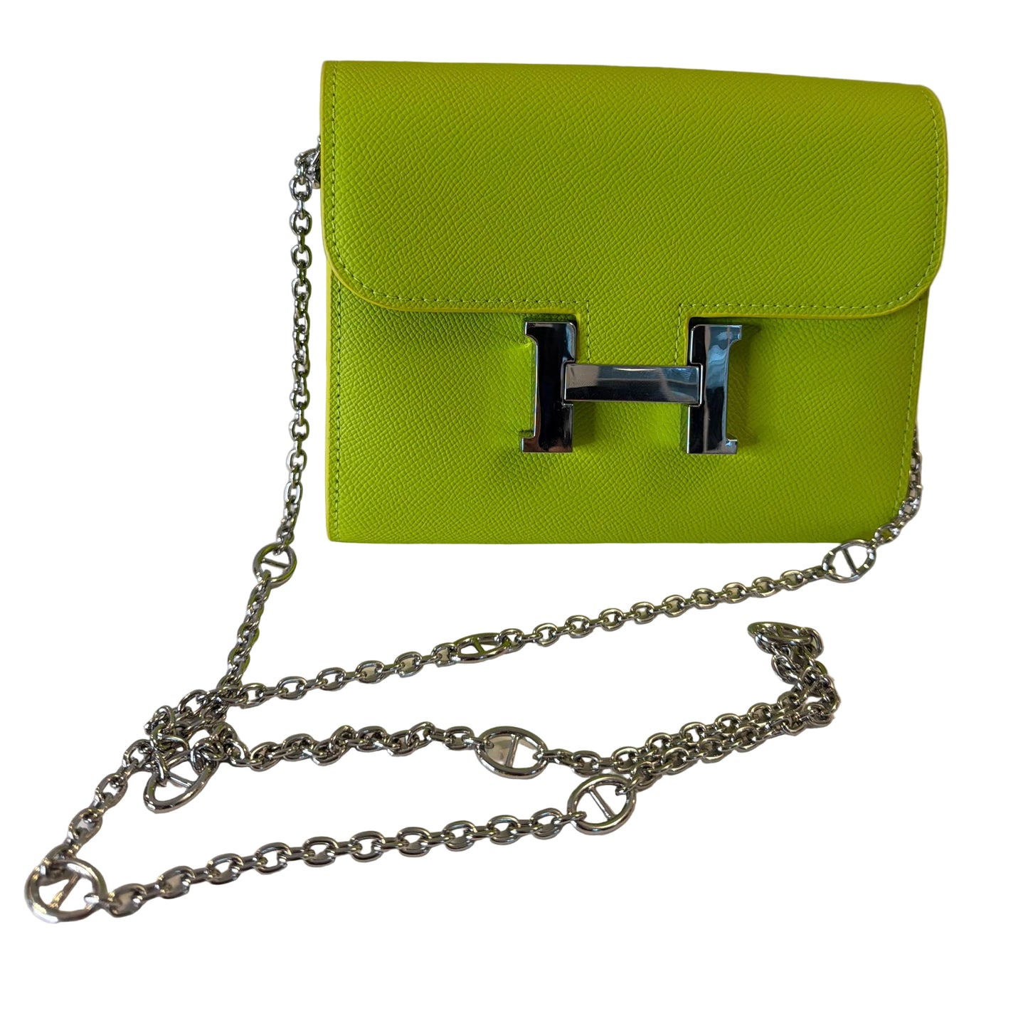 Green handbag with a silver chain on a white surface