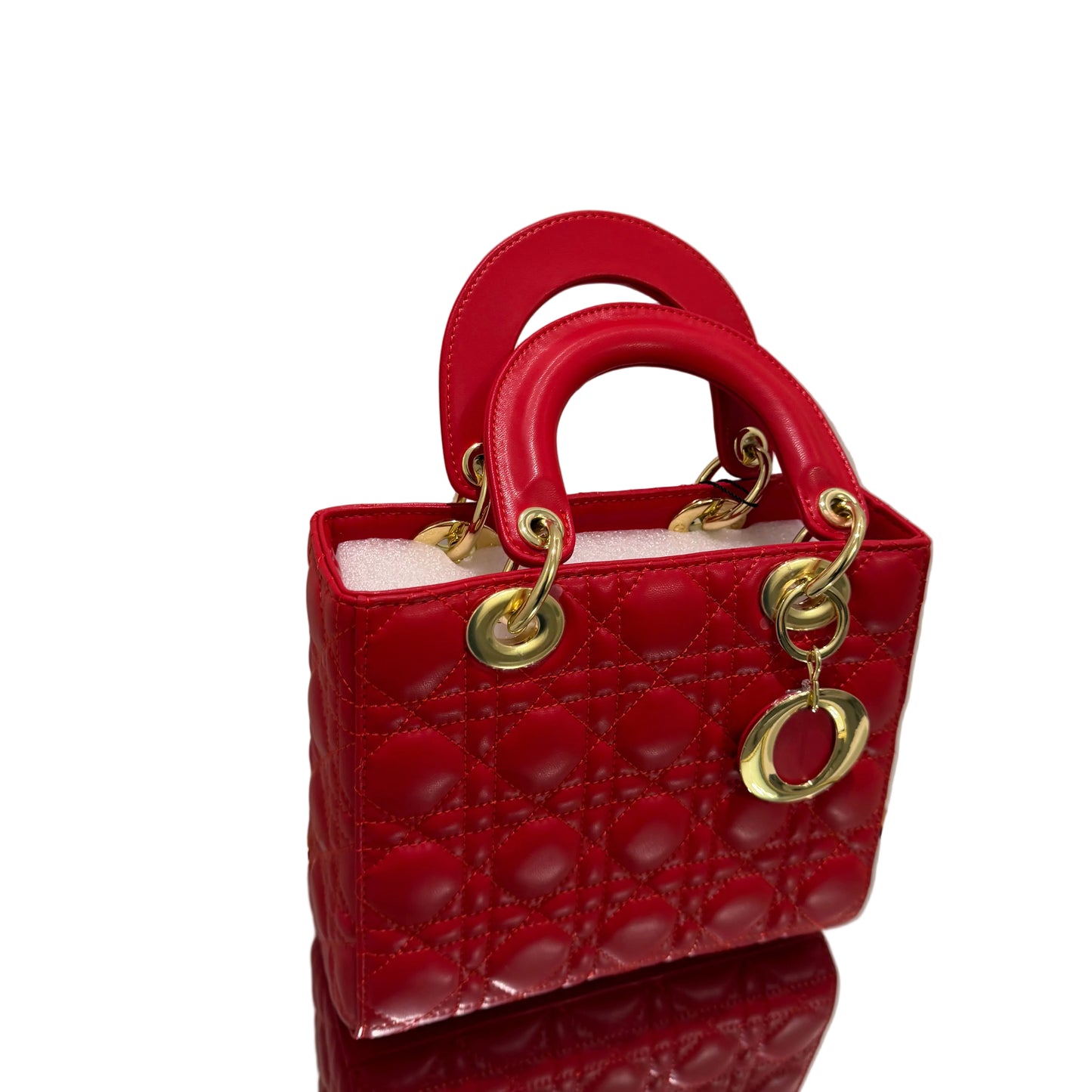Red handbag with gold hardware on a white surface