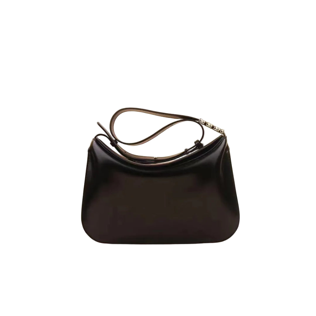 This image features a sleek and stylish black handbag, known as "The Jenny bag." The bag boasts a minimalist design with a smooth, glossy finish and a sophisticated, rounded shape.