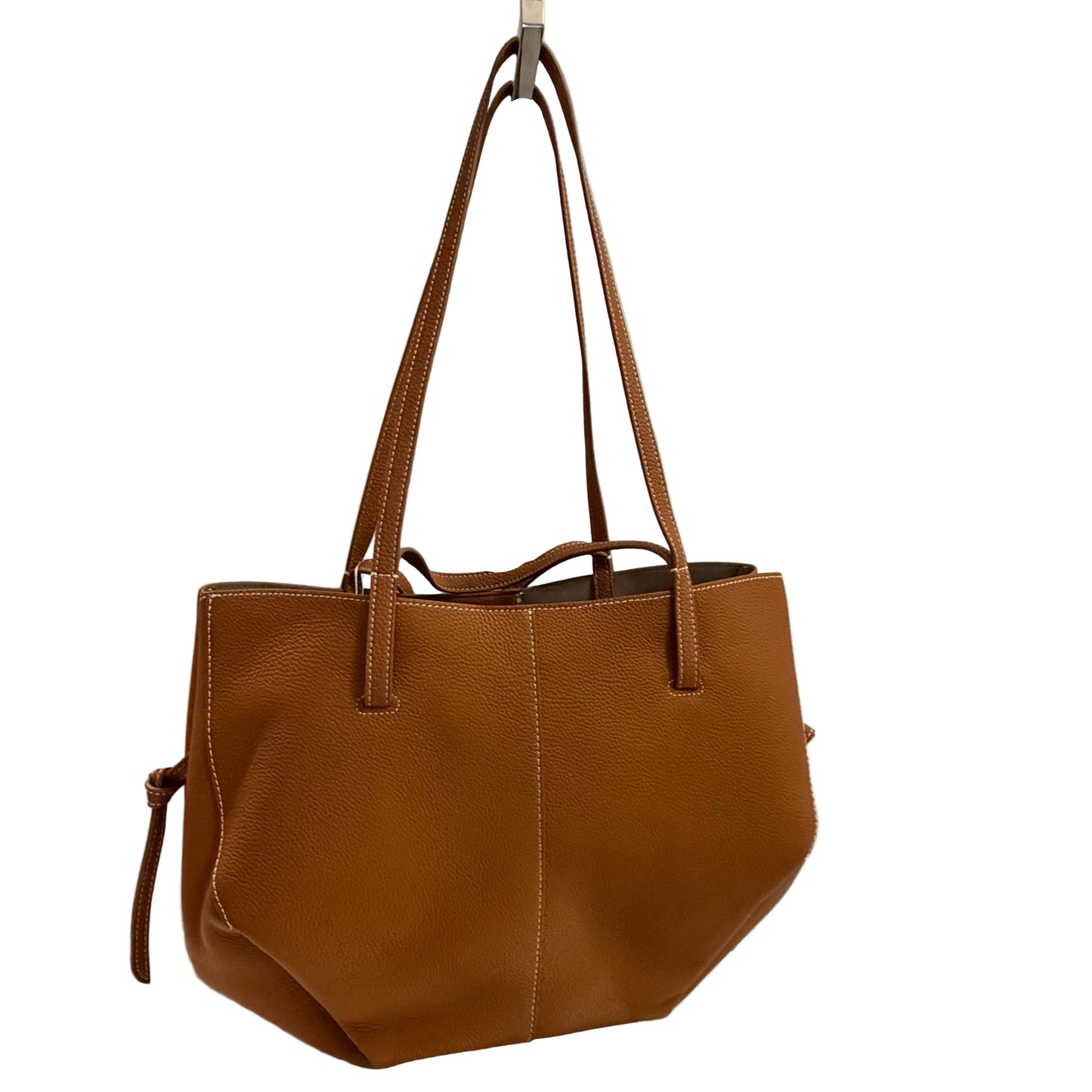 Brown leather handbag on a white surface with a light gray background