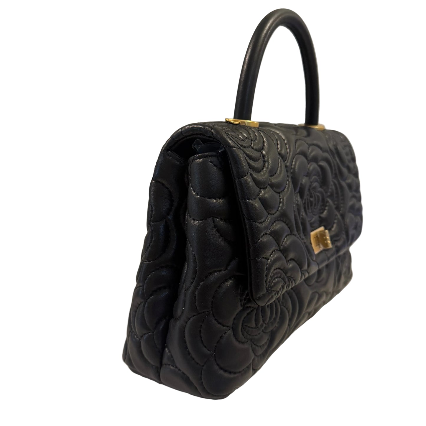 Black quilted handbag with floral patterns on a white surface