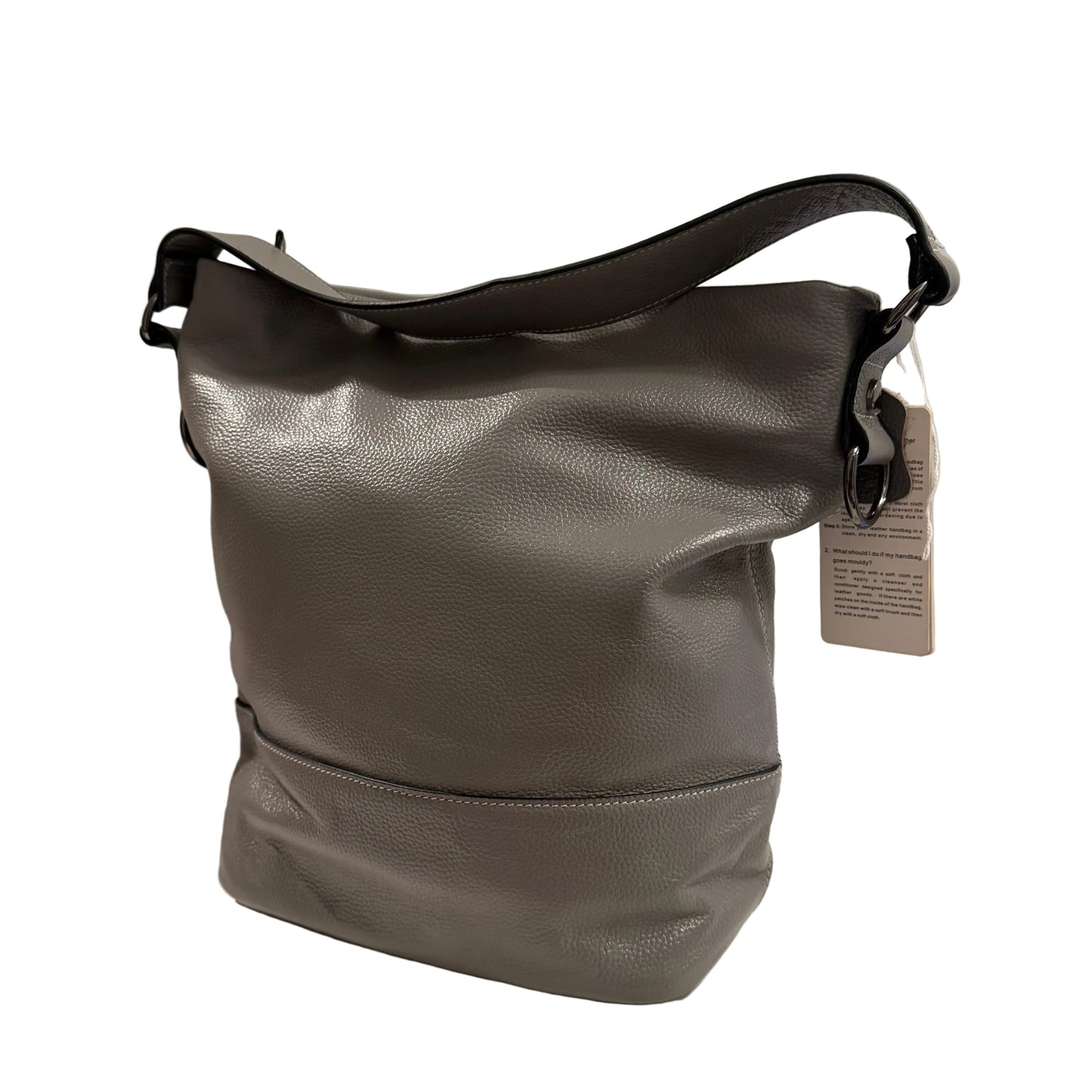 Gray leather handbag with a tag on a light gray background
