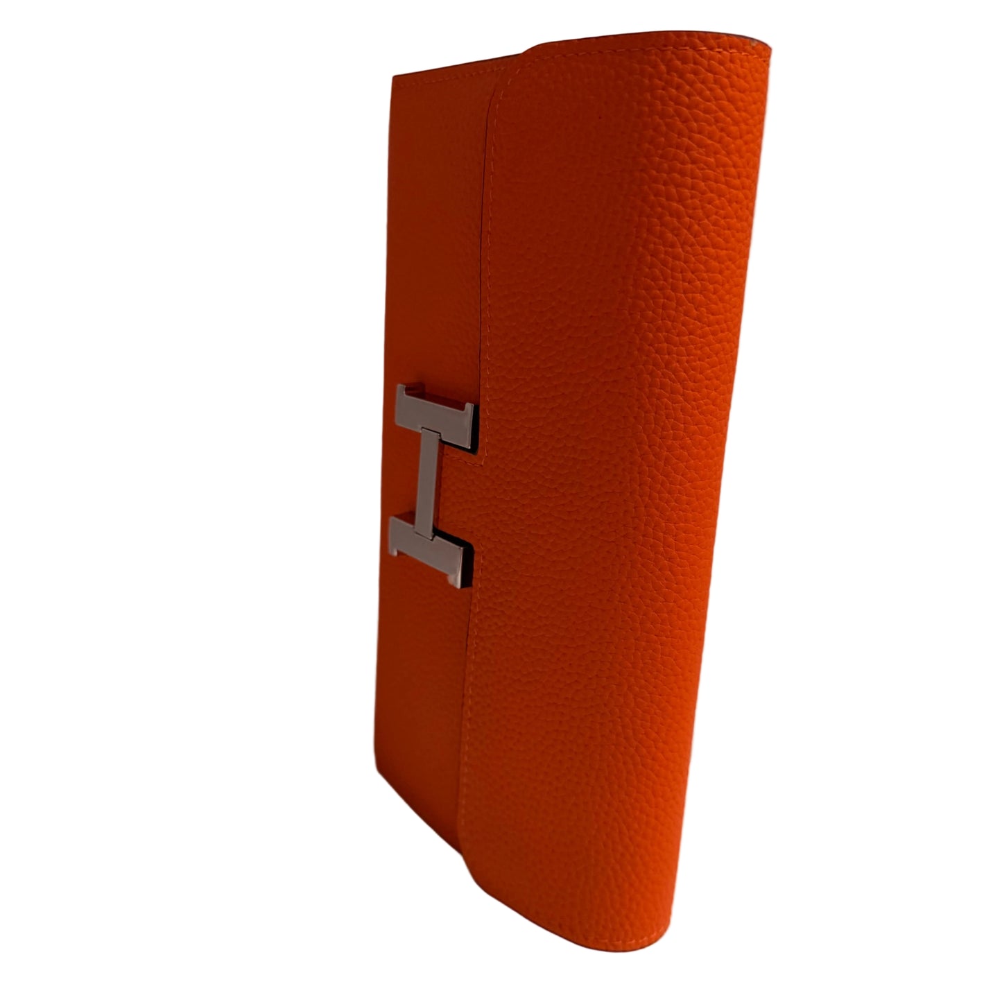 Orange textured clutch bag with a silver 'H' logo on a white background