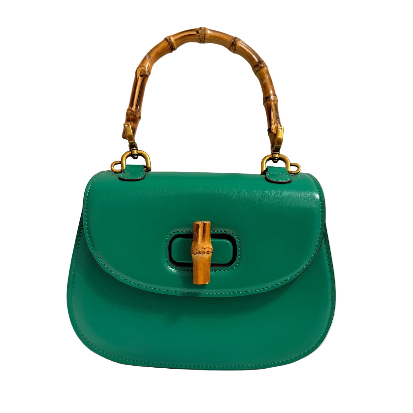 Green handbag with gold bamboo handle and clasp on a neutral background
