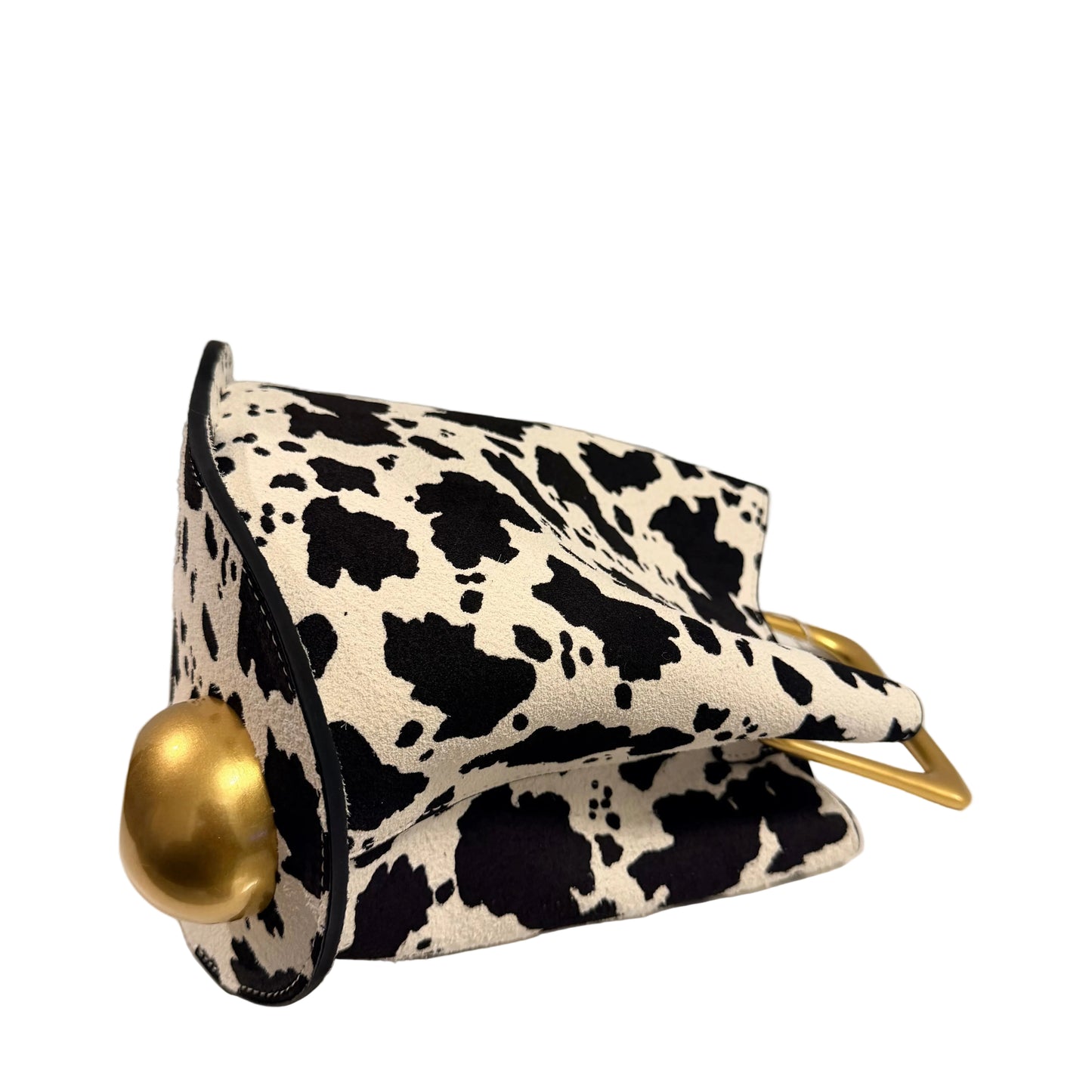 Black and white cow print clutch bag with gold accents on a light gray background