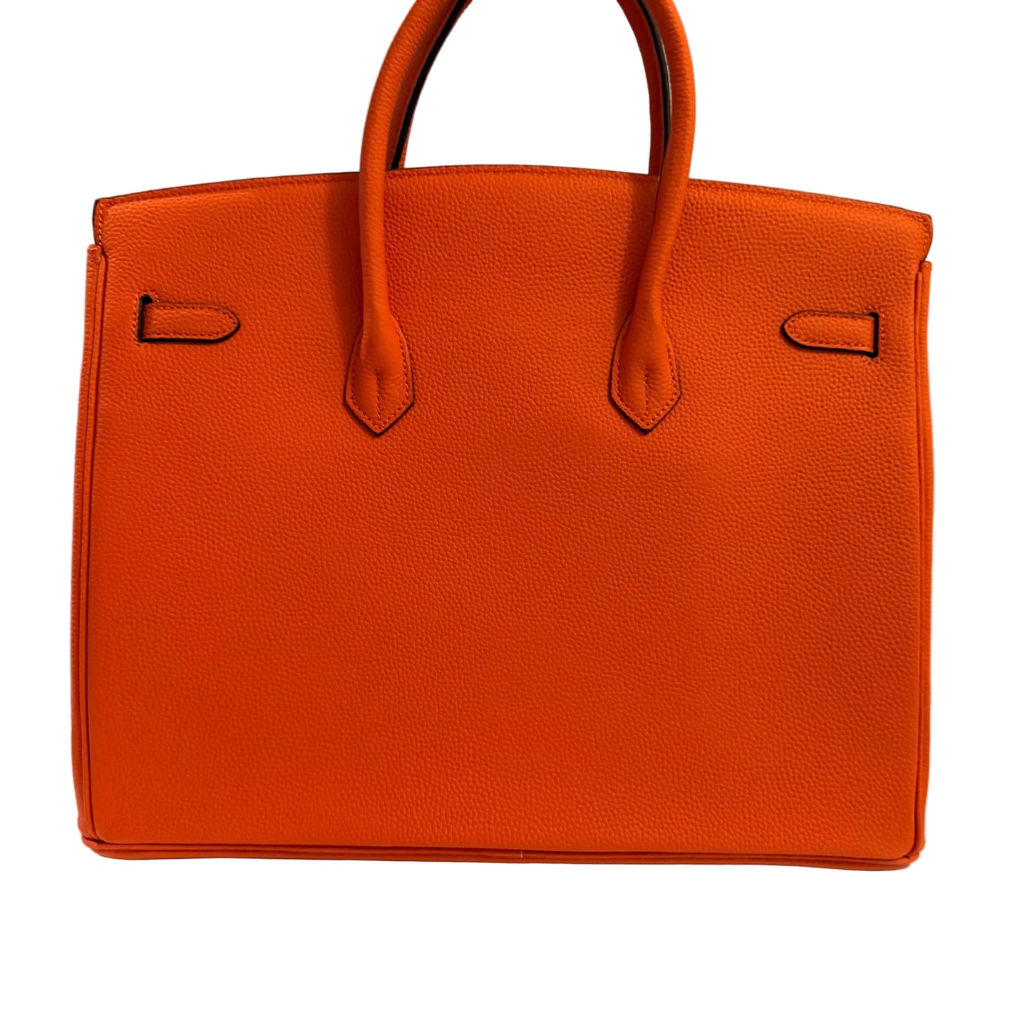 Orange leather handbag on a light gray background