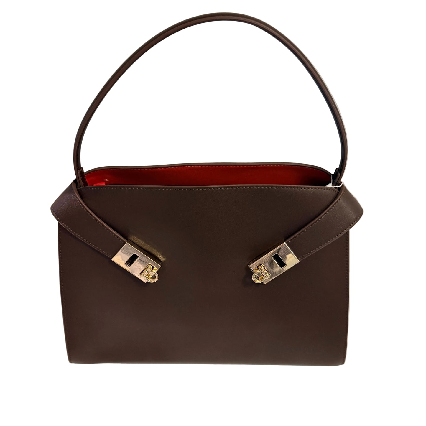Brown handbag with gold hardware on a white surface and light gray background