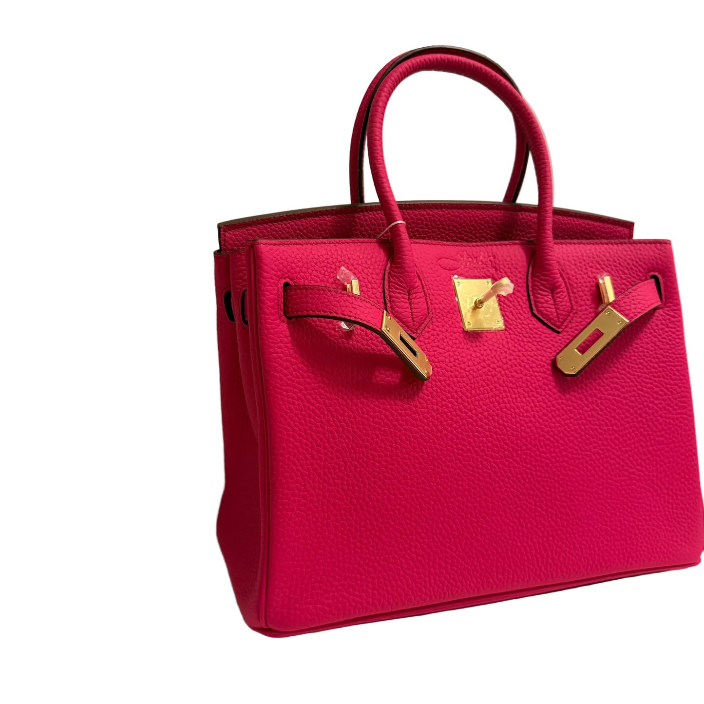 Pink handbag with gold hardware on a light background