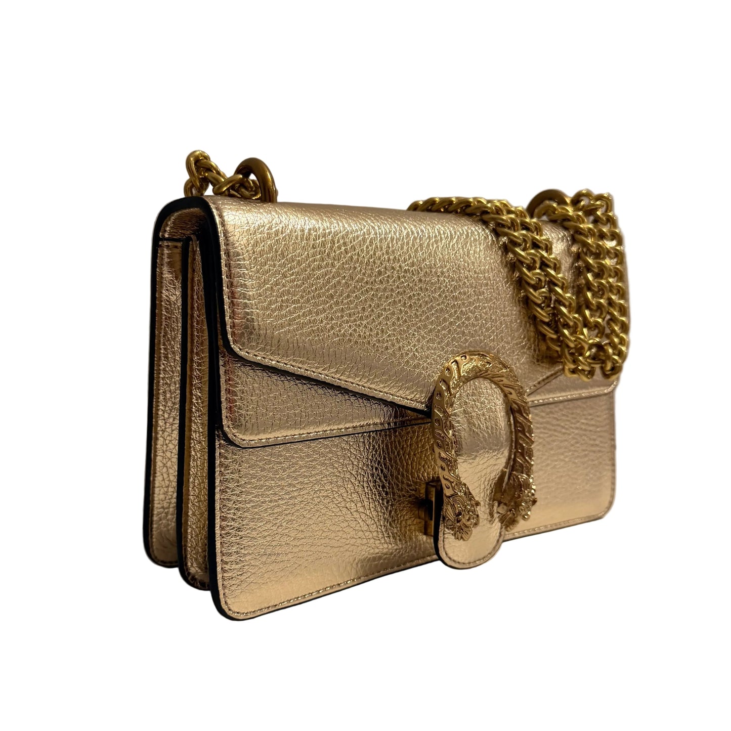 Gold handbag with chain strap on a white surface