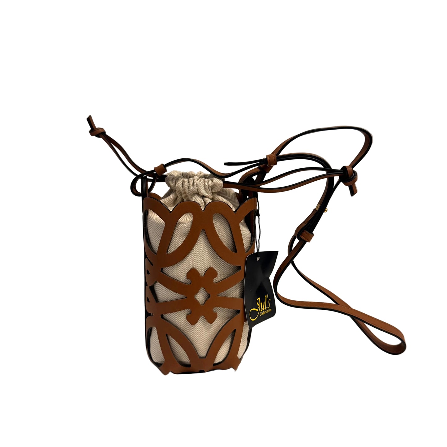 A small drawstring pouch bag with a brown leather geometric cutout pattern over a cream fabric body, featuring a long brown shoulder strap and a black hanging tag with gold lettering, set against a plain light gray background.