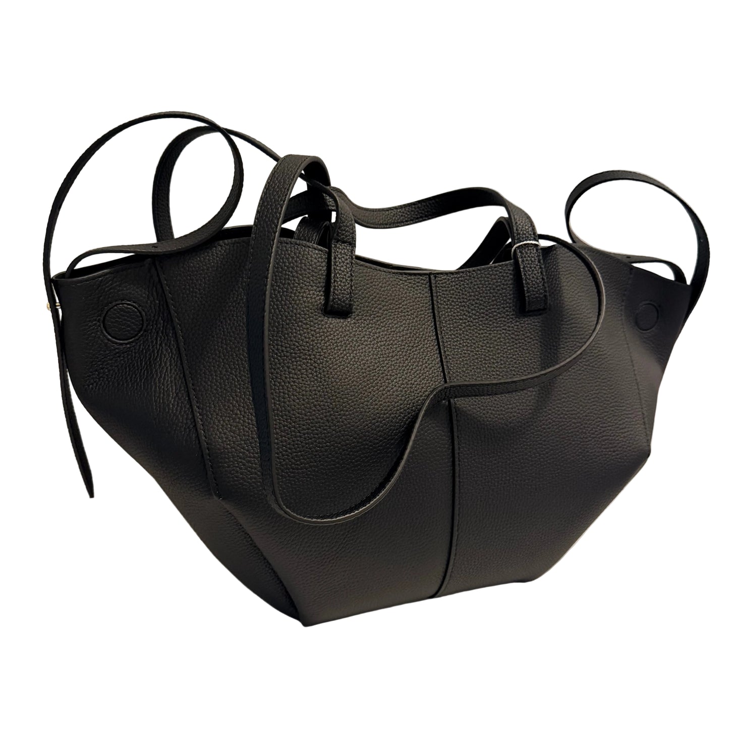 A black pebbled leather tote bag with dual top handles and side loop handles, photographed on a white surface against a light gray wall.