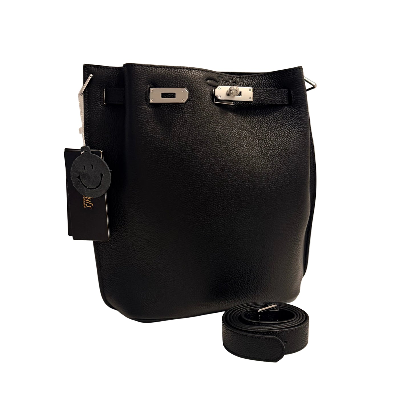 A black pebbled leather bucket bag with silver-tone hardware, shown with its matching detachable shoulder strap coiled in front and a hangtag attached, set against a plain light background.