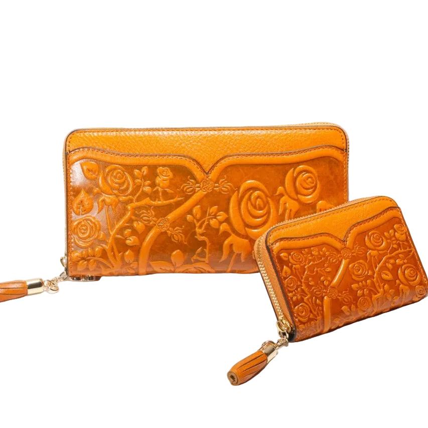 Two orange leather wallets with embossed designs on a white background