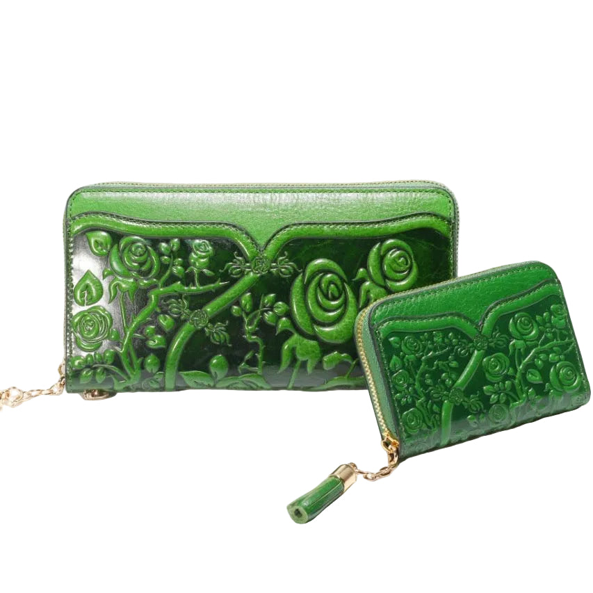Two green embossed wallets with floral designs on a white background
