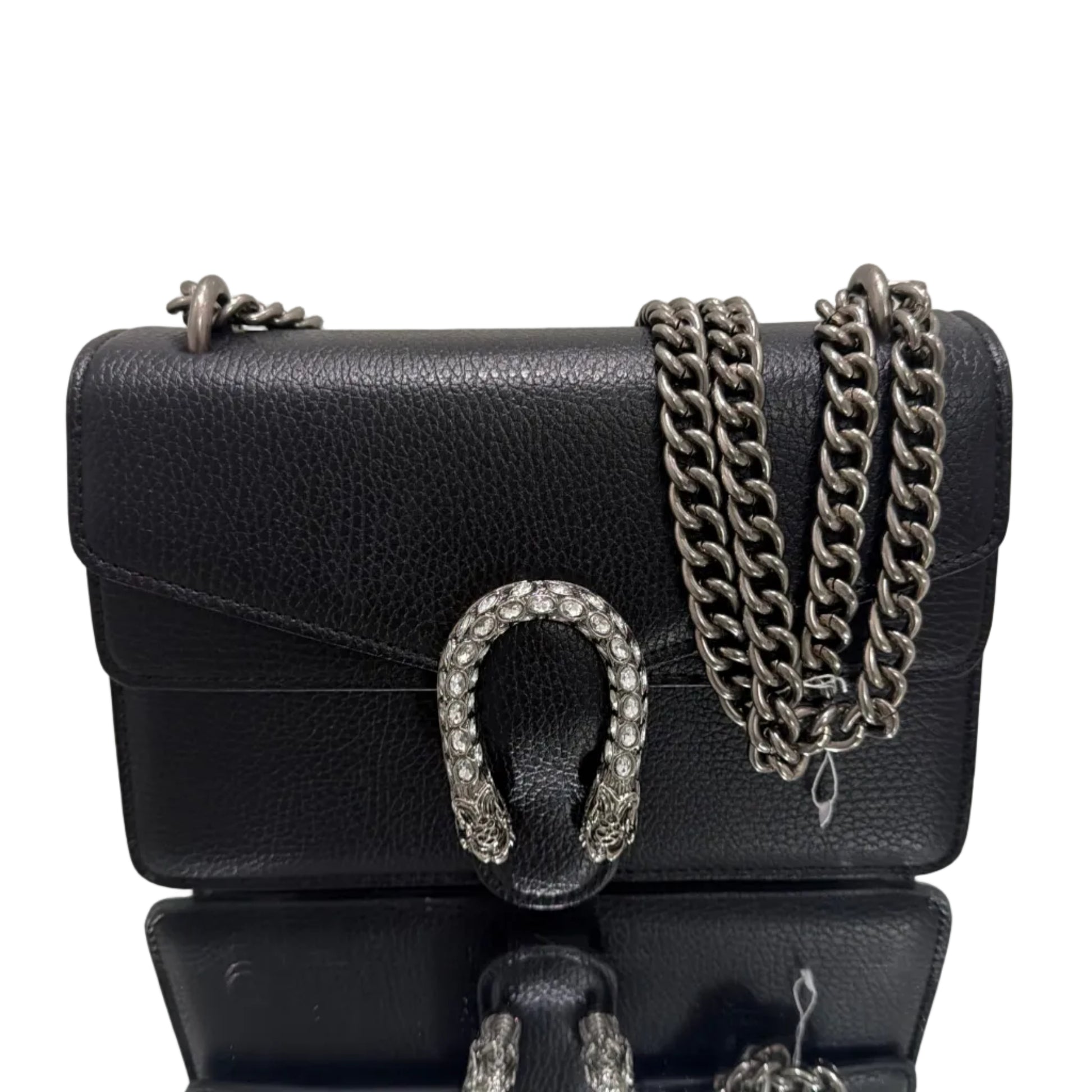 Black leather handbag with chain detail and decorative buckle on a light gray background