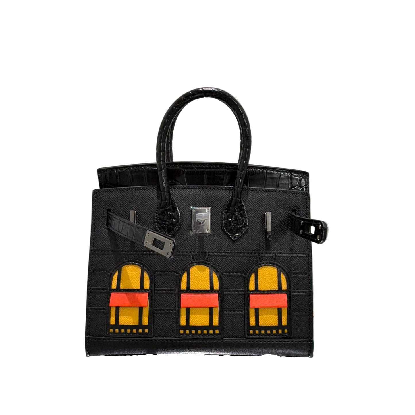 Black handbag with yellow and red accents on a reflective surface