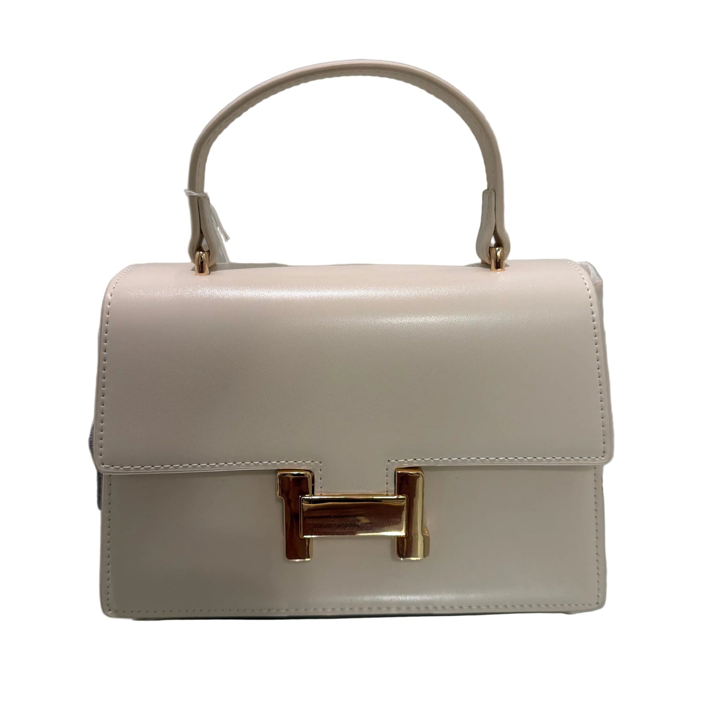 Beige handbag with gold hardware on a reflective surface