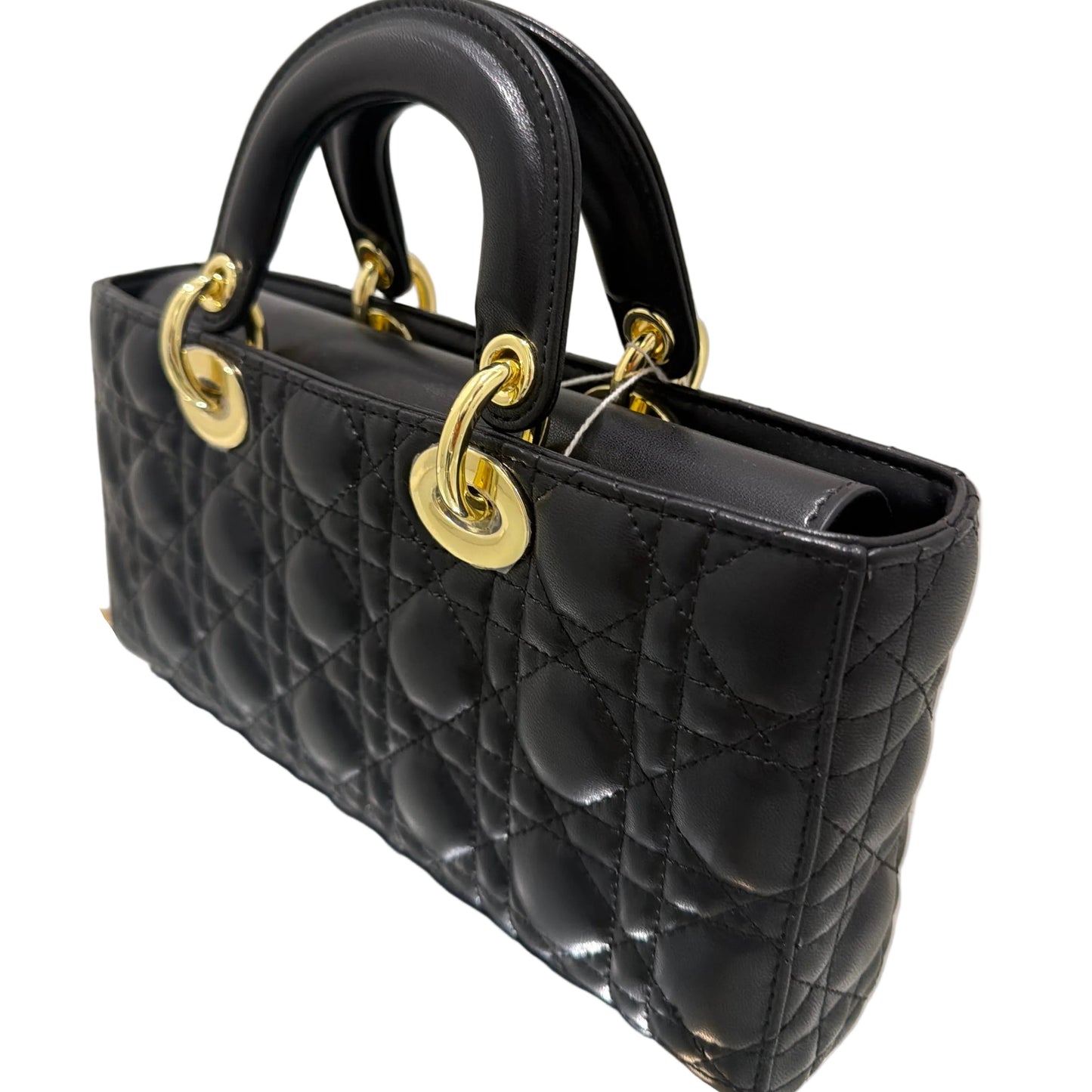 Black quilted handbag with gold hardware on a light gray background