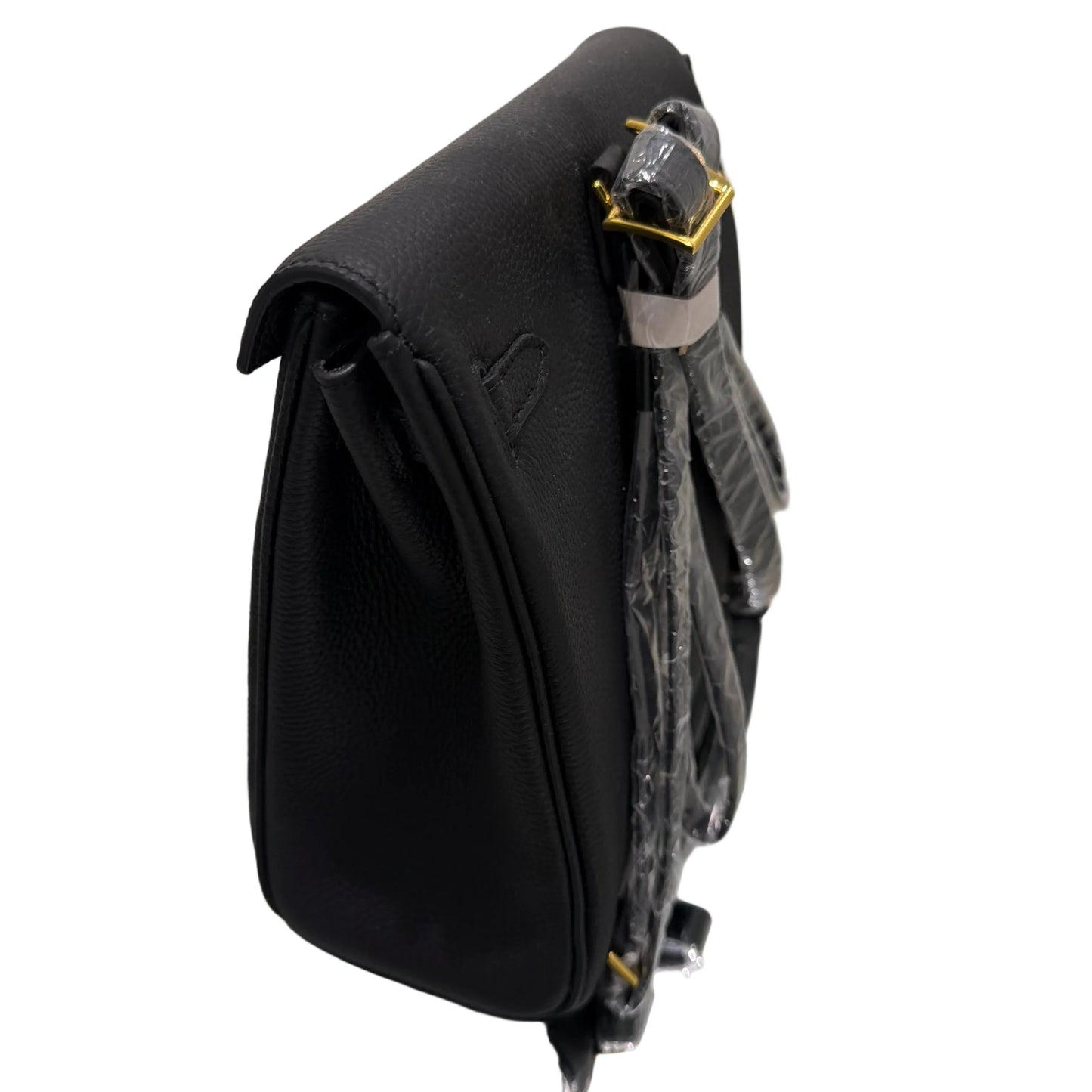 Black leather bag with gold buckle on a reflective surface