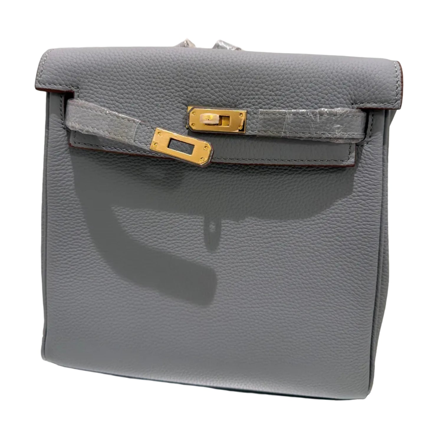 Gray leather handbag with gold hardware on a light background