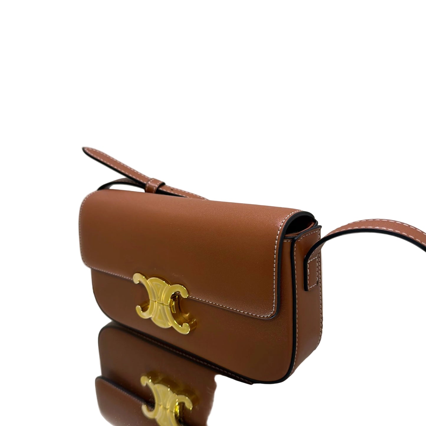 Brown leather handbag with gold accents on a white background