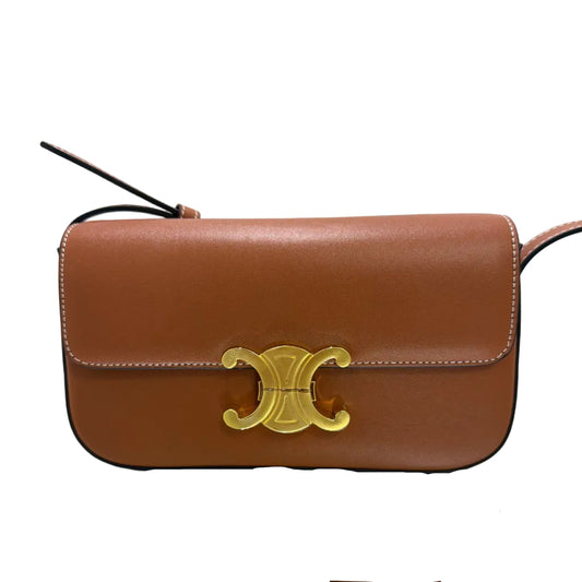Two brown leather bags with gold accents on a light background