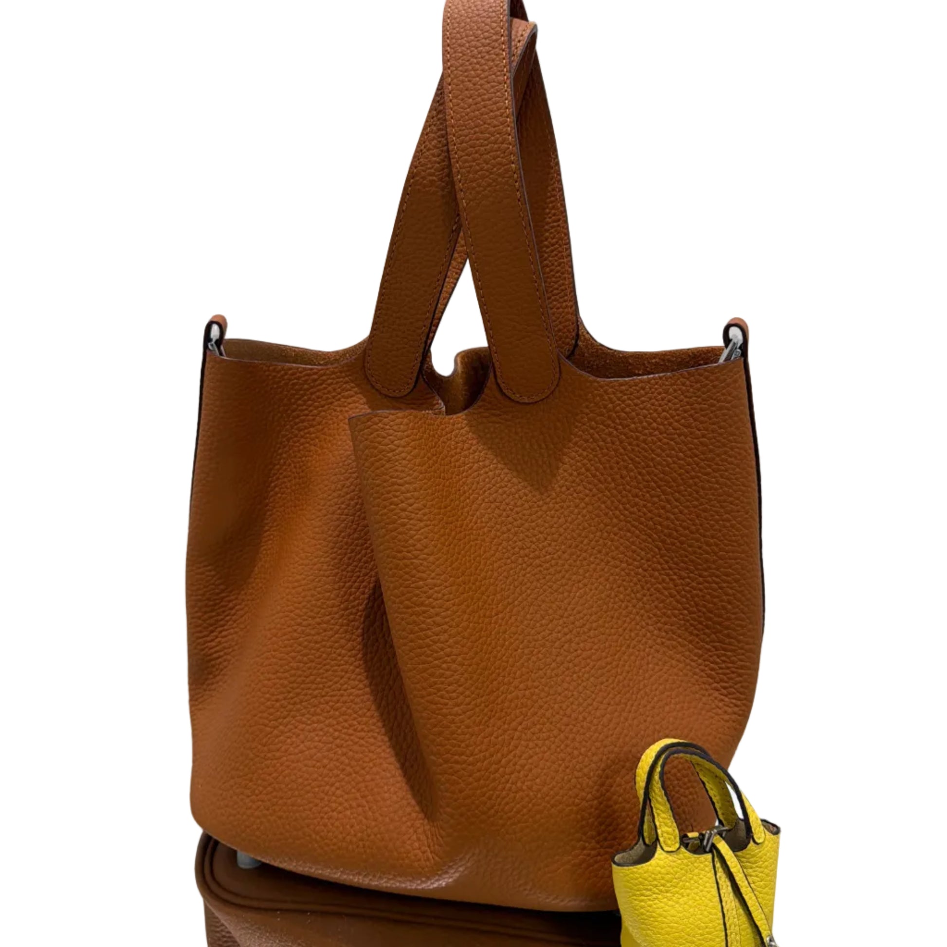 Brown leather handbag with a yellow strap on a white background