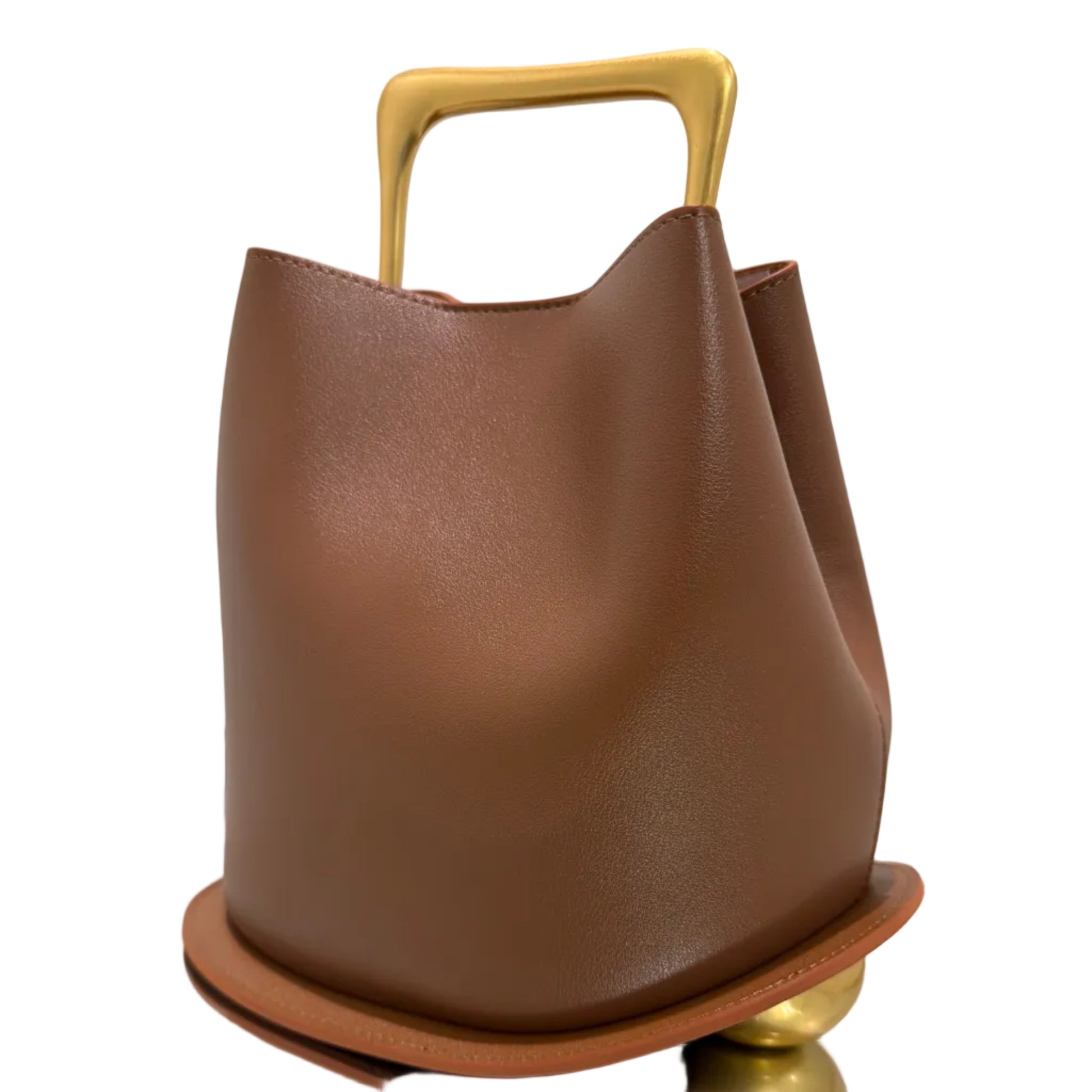 Brown leather handbag with gold handle on a light gray background