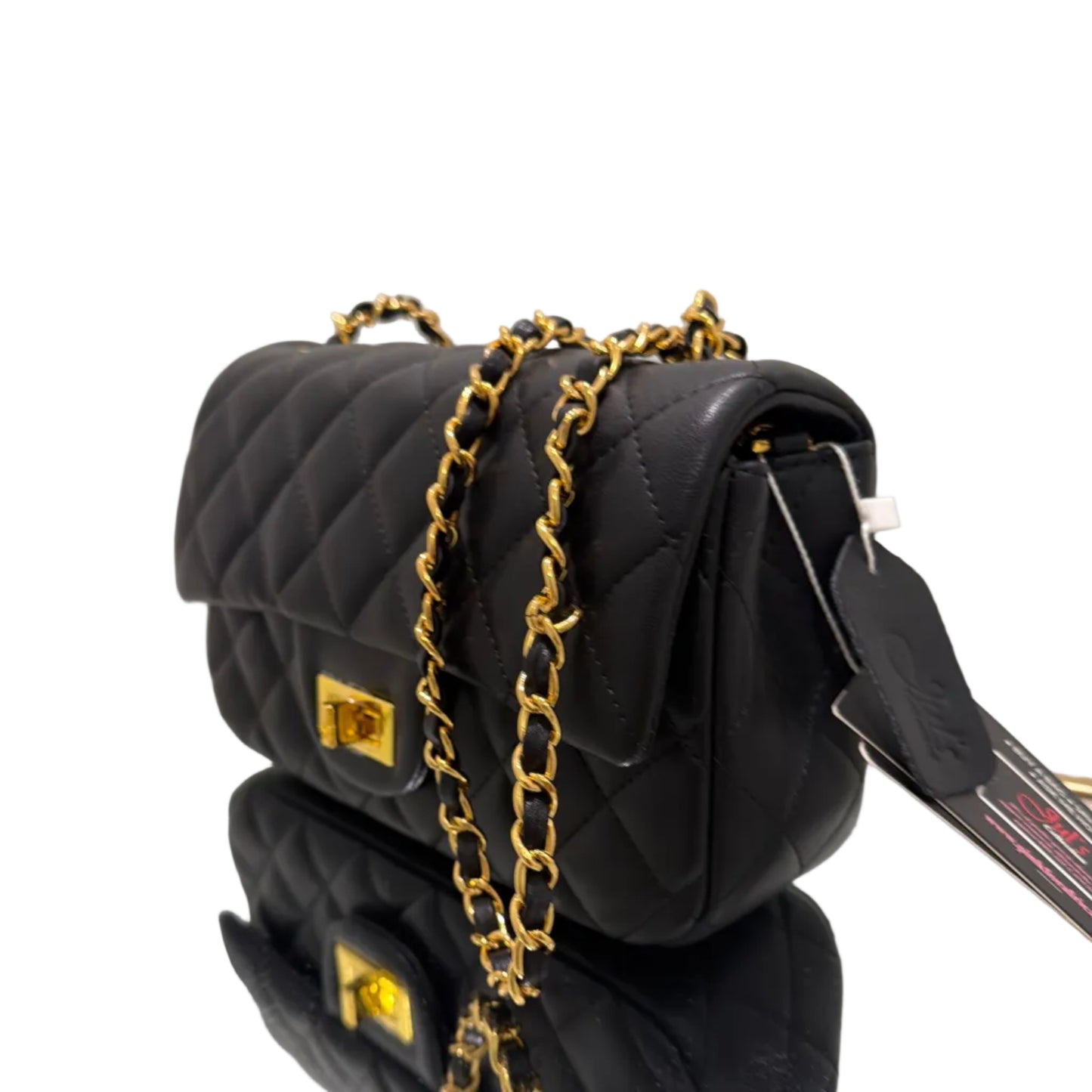 Black quilted handbag with gold chain detail on a white surface