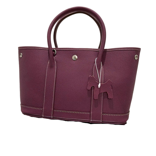 Purple handbag with a bow detail on a light background