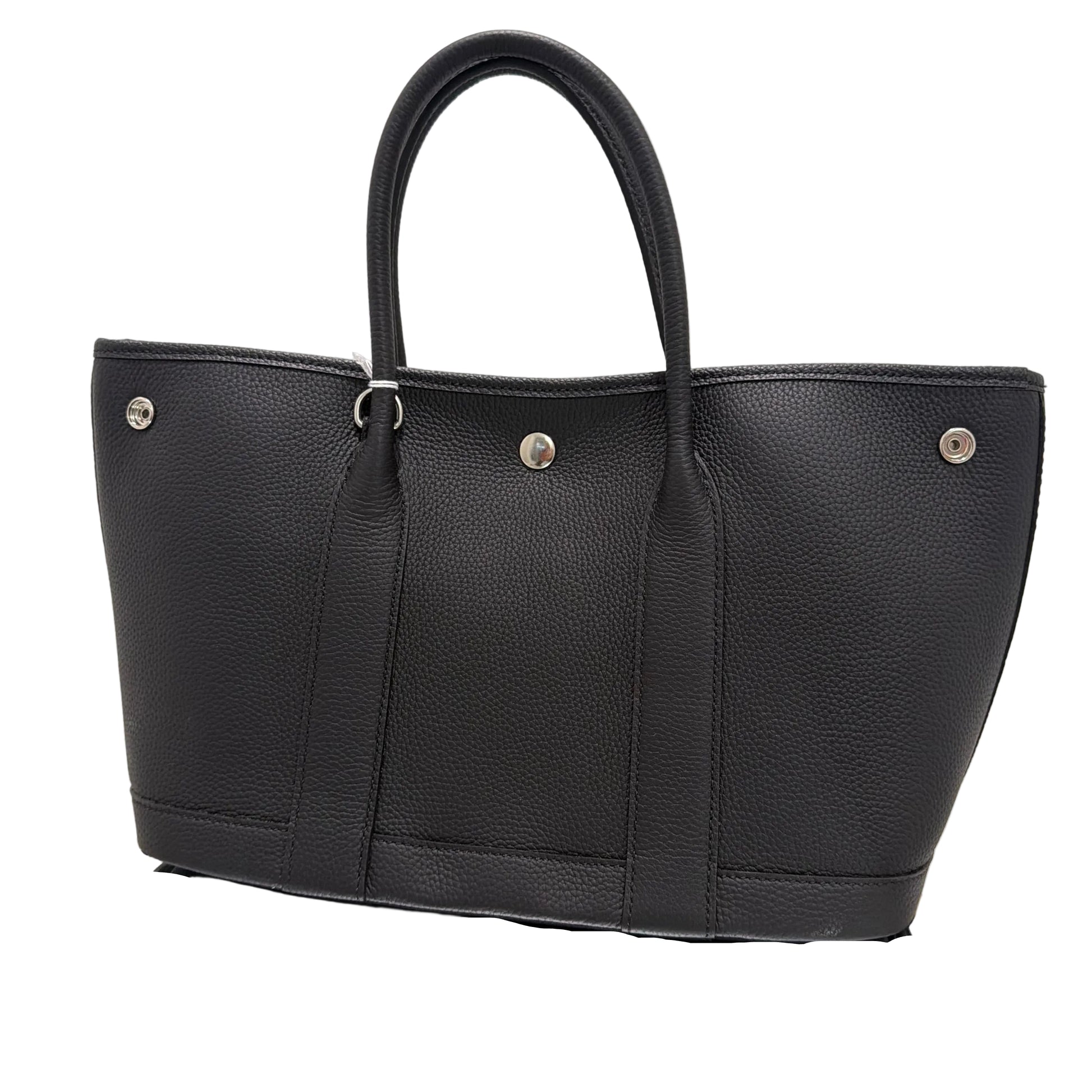 Black leather bag with silver buttons on a light background