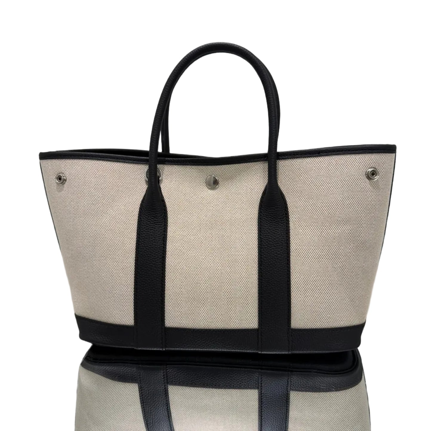 Beige tote bag with black straps on a white background