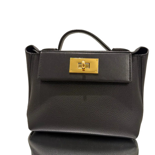 Black leather handbag with a gold clasp on a beige background