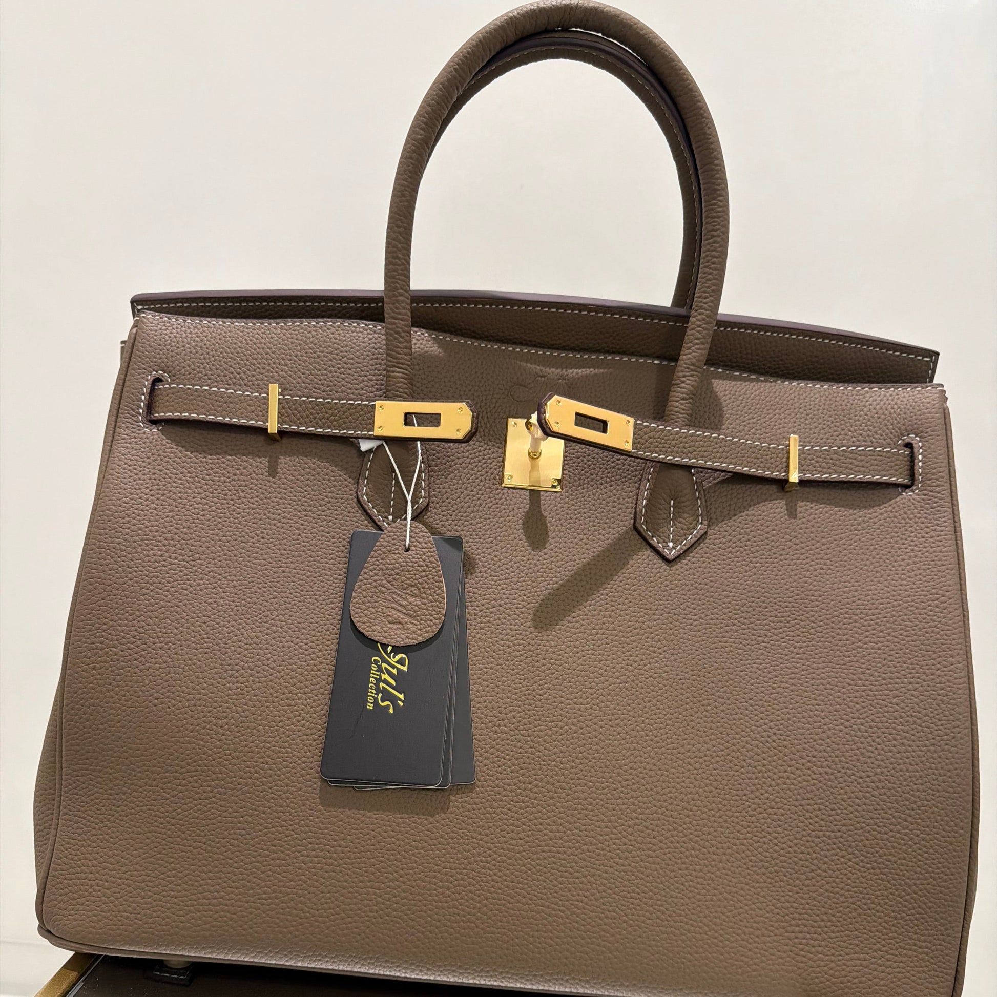 Brown leather briefcase with gold accents on a white background