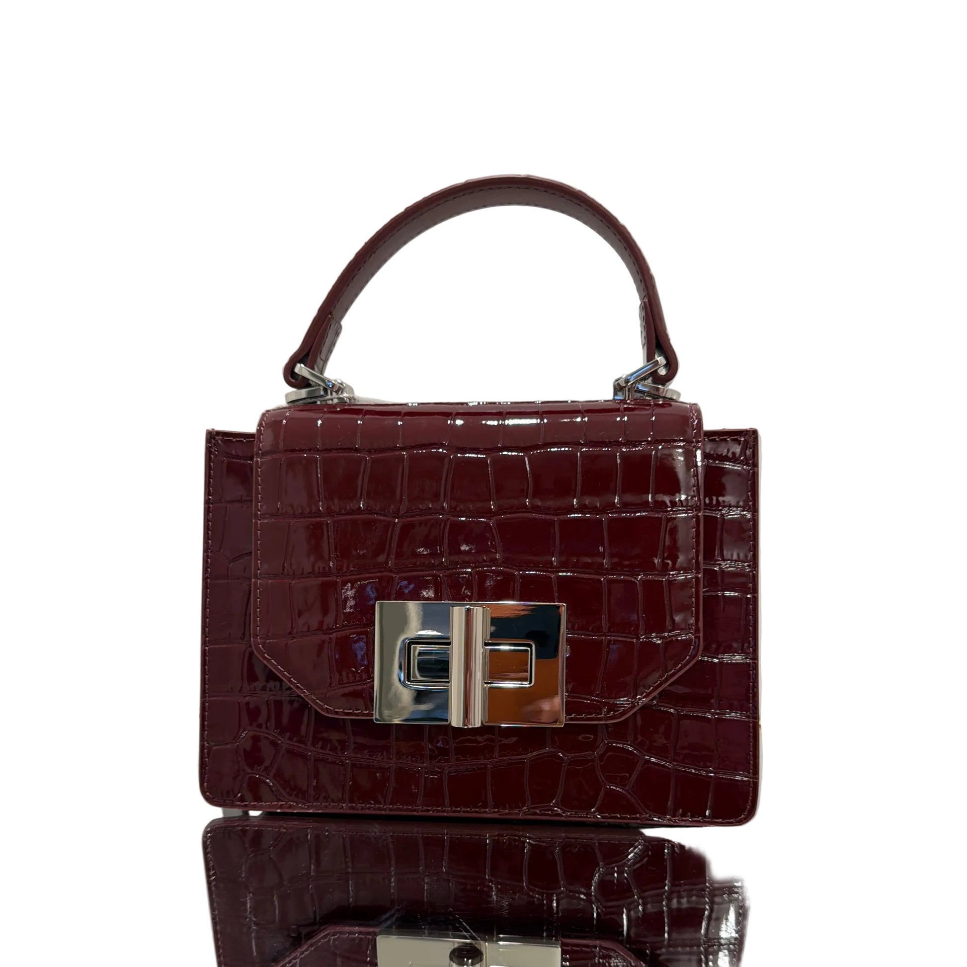 Brown crocodile-patterned handbag with silver clasp on a light gray background