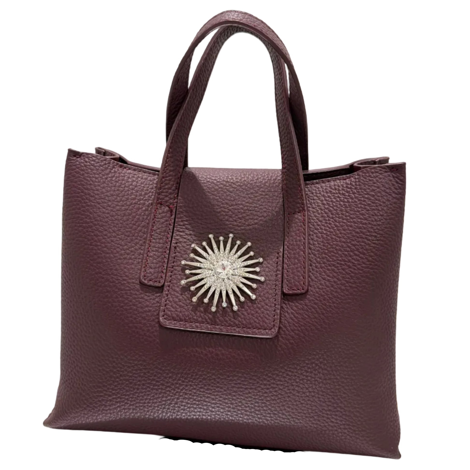 Purple handbag with a decorative emblem on a light background