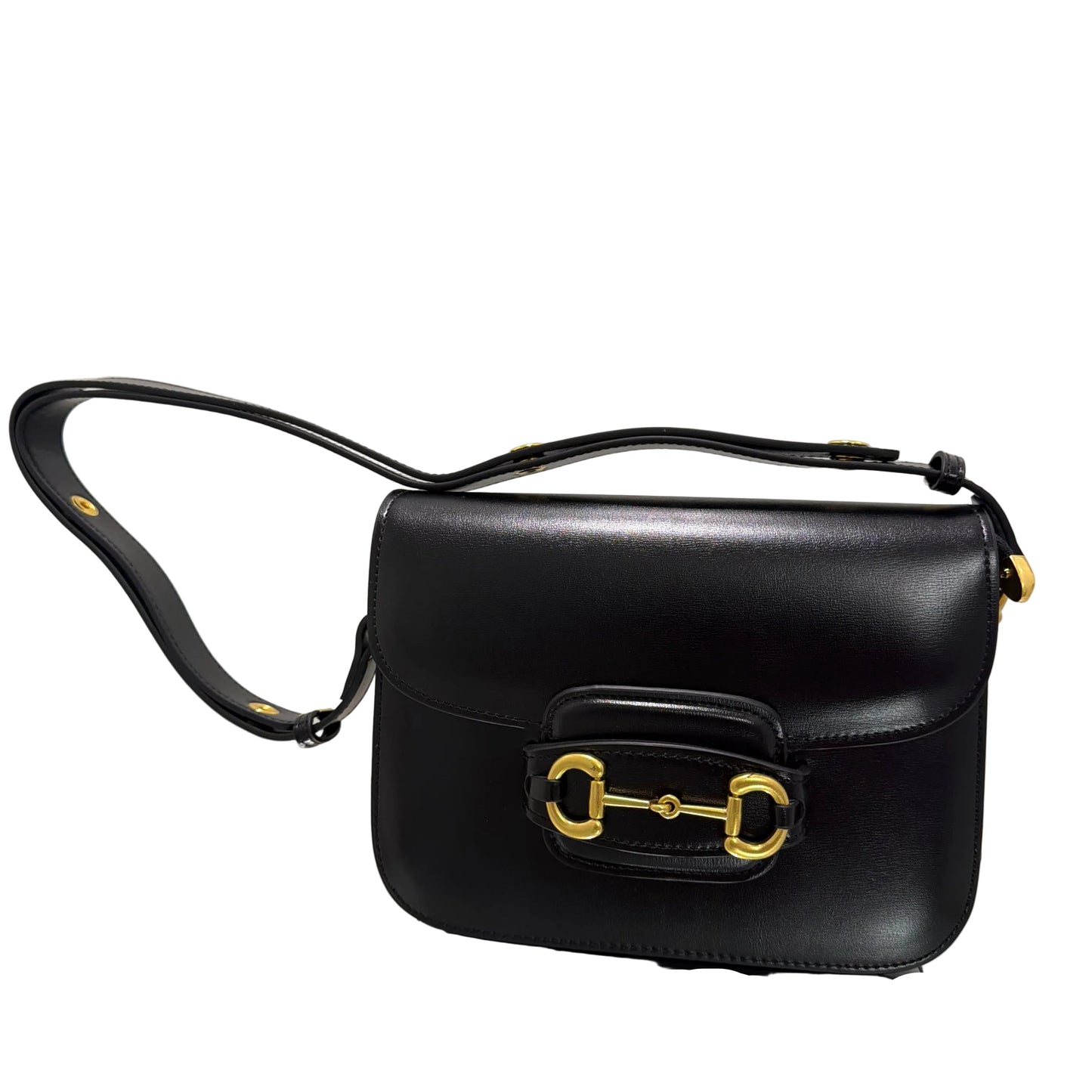 Black handbag with gold hardware on a light gray background
