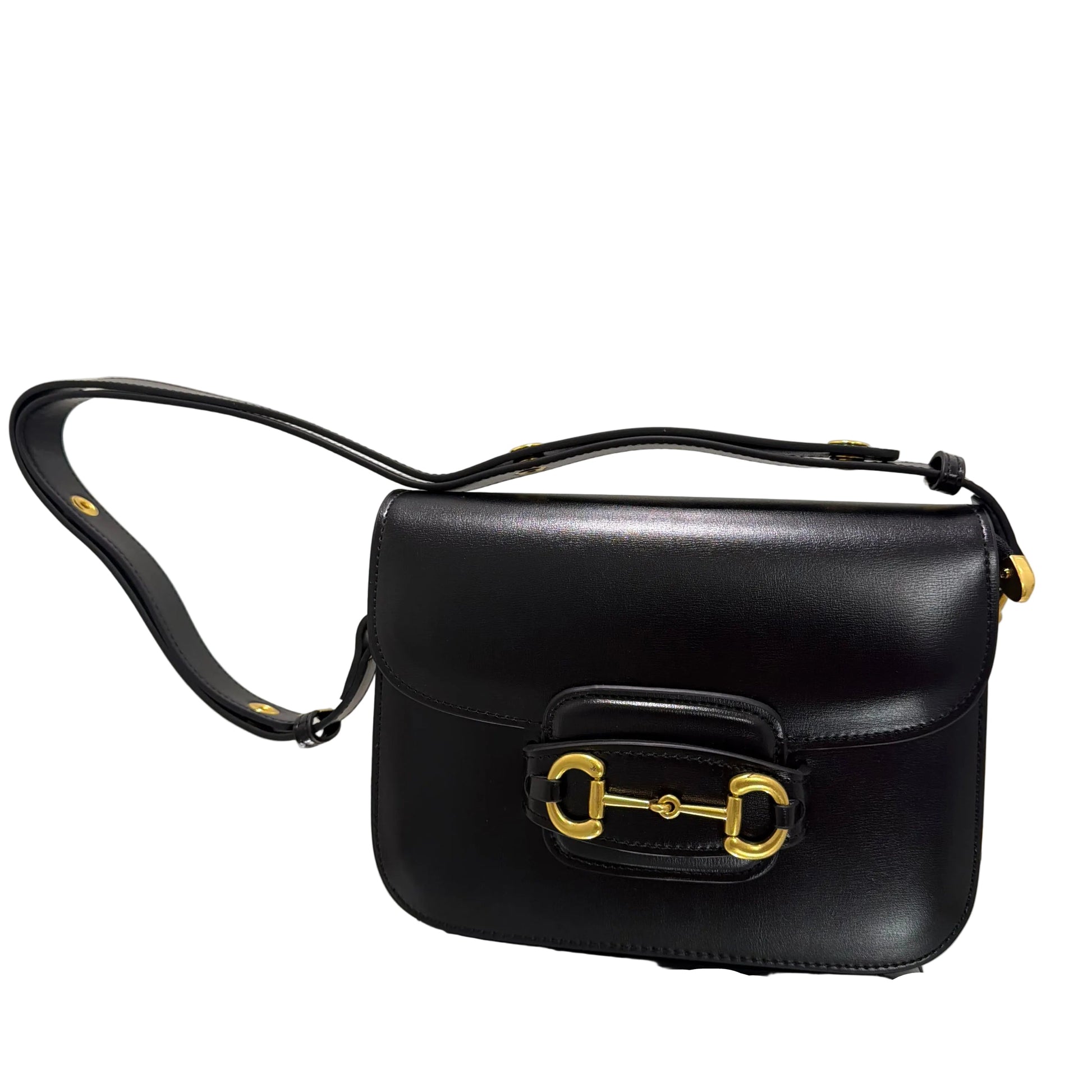 Black handbag with gold hardware on a light gray background